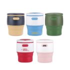 Five insulated travel mugs with lids, each in different color combinations: navy and beige, blue and white, green, red and white labeled Team PRO, and pink and white labeled AFRC. They are arranged in two rows.
