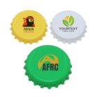 Three bottle caps: a yellow one with a ninja logo, a white one with green and yellow leaves, and a green one with the letters AFRC and a partial mountain logo.