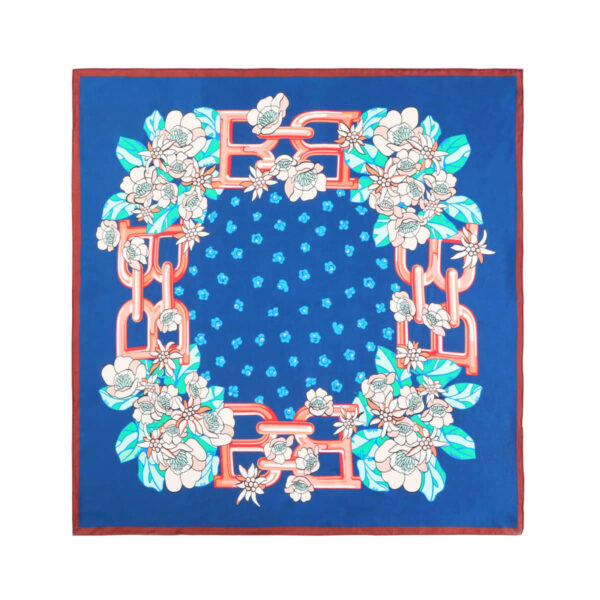 A blue square scarf featuring a floral pattern with white flowers and green leaves. Red chain-like designs frame the flowers, and small blue floral motifs are scattered in the center.