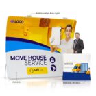 A display setup for a house moving service featuring a large backdrop with a photo of a smiling person holding a clipboard and icons of transportation. A smaller stand shows a graphic of a moving truck. A small figure stands beside the display.