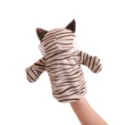 A hand holds a cute, plush tiger hand puppet. The puppet has brown and white stripes, small ears, and a protruding snout. The background is plain white.