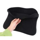 A hand in a green sleeve holds a black, open neoprene laptop sleeve with a zipper. The sleeve appears flexible and expandable, designed to protect and carry a laptop. The background is plain white.