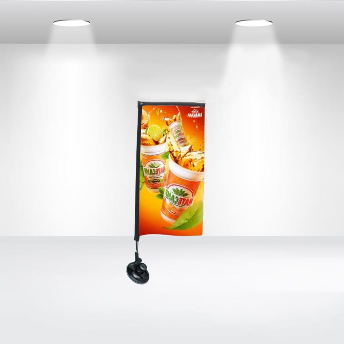 A promotional stand with a bright orange banner displaying images of fruit juice cans, ice cubes, and fruit slices. The banner is set against a minimalist white background, illuminated by ceiling lights.