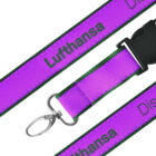 Purple lanyard with black text reading Lufthansa and Discover. It has a metal clip and a black plastic buckle.