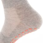 Close-up of a gray sock on a foot, featuring a textured pattern and red grip dots on the sole.