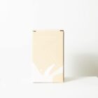 A beige cardboard box with minimalist white abstract designs stands upright on a white surface against a plain white background. The box appears to be unopened.