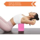 A woman in athletic wear uses a pink yoga block for support while stretching her back on a yoga mat. A text banner above reads, Great for stretches and yoga exercises.