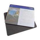 A desk calendar featuring a cityscape photo on the left and a grid for Januarys days on the right, with smaller February and March calendars below. The calendar is atop a dark mat, with branding text visible.