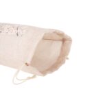 A beige burlap drawstring bag with a floral embroidery design on one side lies open on its side. The fabric texture is coarse, and the drawstring is tied loosely at the end.