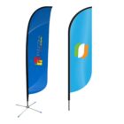 Two vertical banner flags. The left flag is blue with an Electra Colour logo featuring red, yellow, and green squares. The right flag is blue with an abstract orange and green logo. Both flags have black poles and stand on cross bases.