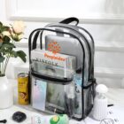 Clear backpack with magazines, a phone, and drinks next to flowers on a white surface.