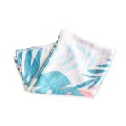Folded white shower curtain with a print of large, light blue and pink tropical leaves against a clean background. The design appears vibrant and summery.
