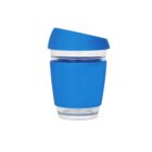A transparent reusable cup with a blue silicone sleeve and a blue lid. The lid is slightly tilted, and the sleeve covers the middle section of the cup, providing grip and insulation.