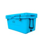 A bright blue cooler with a handle on the side and an embossed logo on the front. It has secured latches on the lid and a drainage plug on the lower front corner. The cooler is set against a plain white background.