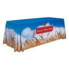 A table covered with a cloth featuring a blue sky with clouds, fields of wheat, and a red sign with a rooster. The sign reads Timmons Natural Farms.