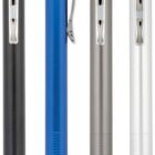 Four retractable ballpoint pens in black, blue, gray, and white, with silver clips and tips, are arranged side by side. Each pen has a textured grip area near the tip.