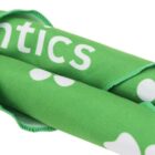 Close-up of a folded, bright green fabric with white text partially visible, showing the letters “ntics.” Parts of white dots are also visible. The edges of the fabric are neatly stitched.