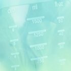 Close-up of a translucent measuring cup showing volume measurements in cups, milliliters, and fluid ounces. The markings include 750 ml, 1000 ml, 1250 ml, and 1500 ml, with corresponding fluid ounce and cup equivalents.