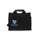 A black fabric tote bag with two front pockets featuring a blue logo of a leaf design and the text GreenChoice Your Tagline Goes Here. The bag has short handles and a sleek design.