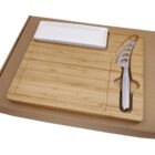 A set featuring a wooden cheese board with a groove for a knife, a stainless steel cheese knife with a hole design, and a rectangular white ceramic dish, all packaged in a cardboard box.