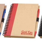 Three spiral-bound notebooks with pens attached. Each notebook has a colored stripe: blue, red, and black. The cover reads Sink Em Swimwear with the logo matching the color of the stripe.