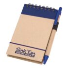 A small spiral-bound notebook with a blue and brown cover, featuring a pen attached on the right side by an elastic loop. The notebook has Sink Em Swimwear printed on the cover.