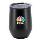 A black tumbler with a transparent lid featuring the NBC logo, which includes a colorful peacock design above the white letters NBC.