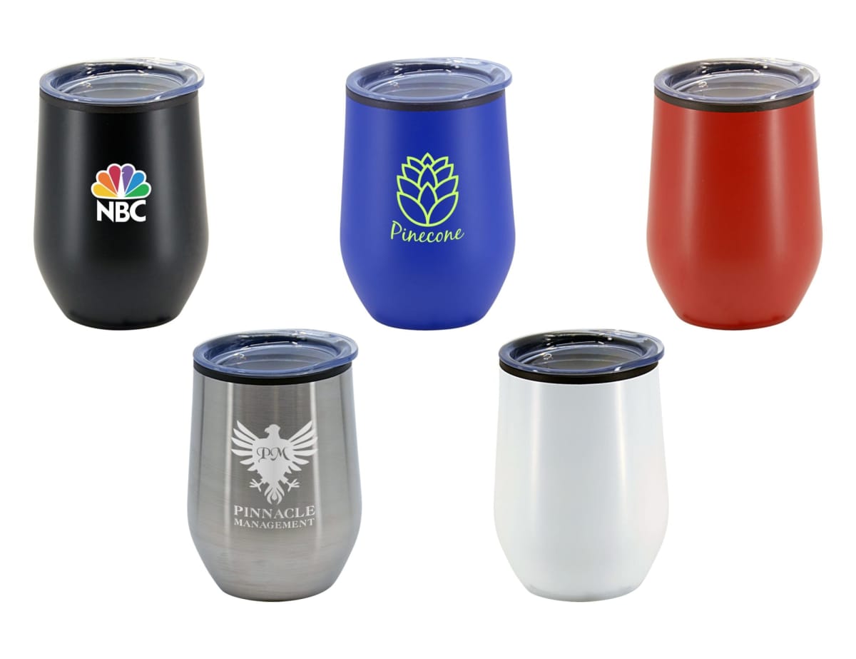 Five insulated tumblers with clear lids, each a different color: black with a NBC logo, blue with a pinecone image, red, silver with an eagle design labeled Pinnacle Management, and white. Each tumbler has a sleek, stemless design.