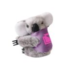 Stuffed koala toy with fluffy gray fur and white ears, holding a black fork. It wears a purple blanket with a pink geometric design and the word COMPANY partially visible. .