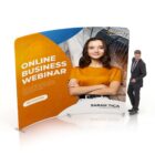 A man in a suit stands next to a large curved display featuring a woman with crossed arms and a confident smile. The display reads Online Business Webinar and includes a Get Started button. The background has abstract designs.