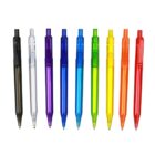 A row of nine ballpoint pens shown against a white background. The pens are in various transparent colors: black, clear, purple, blue, green, yellow, orange, and red, arranged from left to right.
