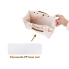 A hand is inserting a removable polypropylene base mat into a beige fabric organizer with pockets. An arrow points to the mat with the label Removable PP base mat below.
