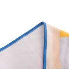 Close-up of a corner of a soft blanket with blue stitched edges. The blanket features a subtle abstract pattern with beige and yellow hues, against a white background.