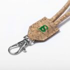 A close-up of a cork lanyard with a metal swivel clip, featuring a green logo with the word BORDER on the cork section. The lanyard lies on a white background.