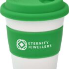 A reusable white coffee cup with a green silicone lid and grip. The grip has the text ETERNITY JEWELLERS and a logo printed in white.