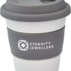 A reusable white and gray coffee cup with a silicone lid and sleeve. The sleeve features the Eternity Jewellers logo in white text.