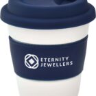 A white reusable coffee cup with a navy blue silicone lid and band. The band features the logo and text Eternity Jewellers in white. The cup has a modern, eco-friendly design.