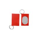 Two red keychain mirrors are shown. One mirror is in a closed case, while the other is open, revealing an oval reflective surface. Both have metal key rings attached.