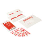 A collection of first aid supplies including individually wrapped gauze pads, antiseptic wipes, bandages, and a red and white instruction booklet. Items are displayed on a white background.