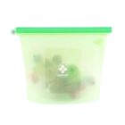 A translucent silicone food storage bag with a green zip seal, partially filled with assorted fruits. The front of the bag features a small logo with the word greenlife and an icon of a leaf.
