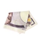 A folded towel designed to look like a banknote, featuring intricate patterns and part of a portrait.
