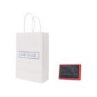 A white Air Mail bag and a red rubber stamp with text.