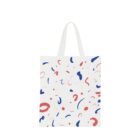 A white tote bag with abstract red and blue squiggles and dots scattered across its surface. The bag has two white handles.