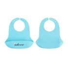 Two blue silicone baby bibs are shown. One is open with adjustable holes, while the other is closed. The open bib has a pocket with the word idero printed on it in black.