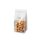 A clear bag with a white top, containing small, star-shaped biscuits. The bag features a simple flower logo. The biscuits have various patterns on them and are visible through the transparent section.