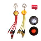 Two charging cable keychains: one with a red shell design and one with a yellow jack-o-lantern design. Both have multiple connectors. Circular images show glowing effects with a panda and shell design. A red custom label is in the upper right corner.