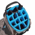 A golf bag with a light brown exterior and a vivid blue, 14-way top divider for organizing clubs. The bag features multiple zippered compartments and a padded shoulder strap.