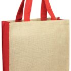 A beige jute tote bag with red fabric handles and red sides. The bag is standing upright, showcasing its rectangular shape and sturdy construction.