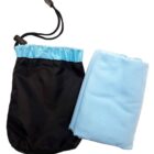 A folded light blue blanket next to a black drawstring pouch with a blue trim at the opening. The pouch has a plastic toggle closure on the drawstring.