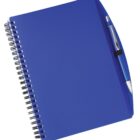 A blue spiral notebook with a blue pen attached to its cover using a black elastic band. The notebook is slightly tilted to the right, and the pen has silver accents.
